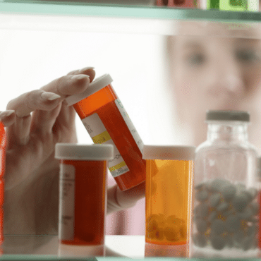 Hand Reaching into Medicine Cabinet
